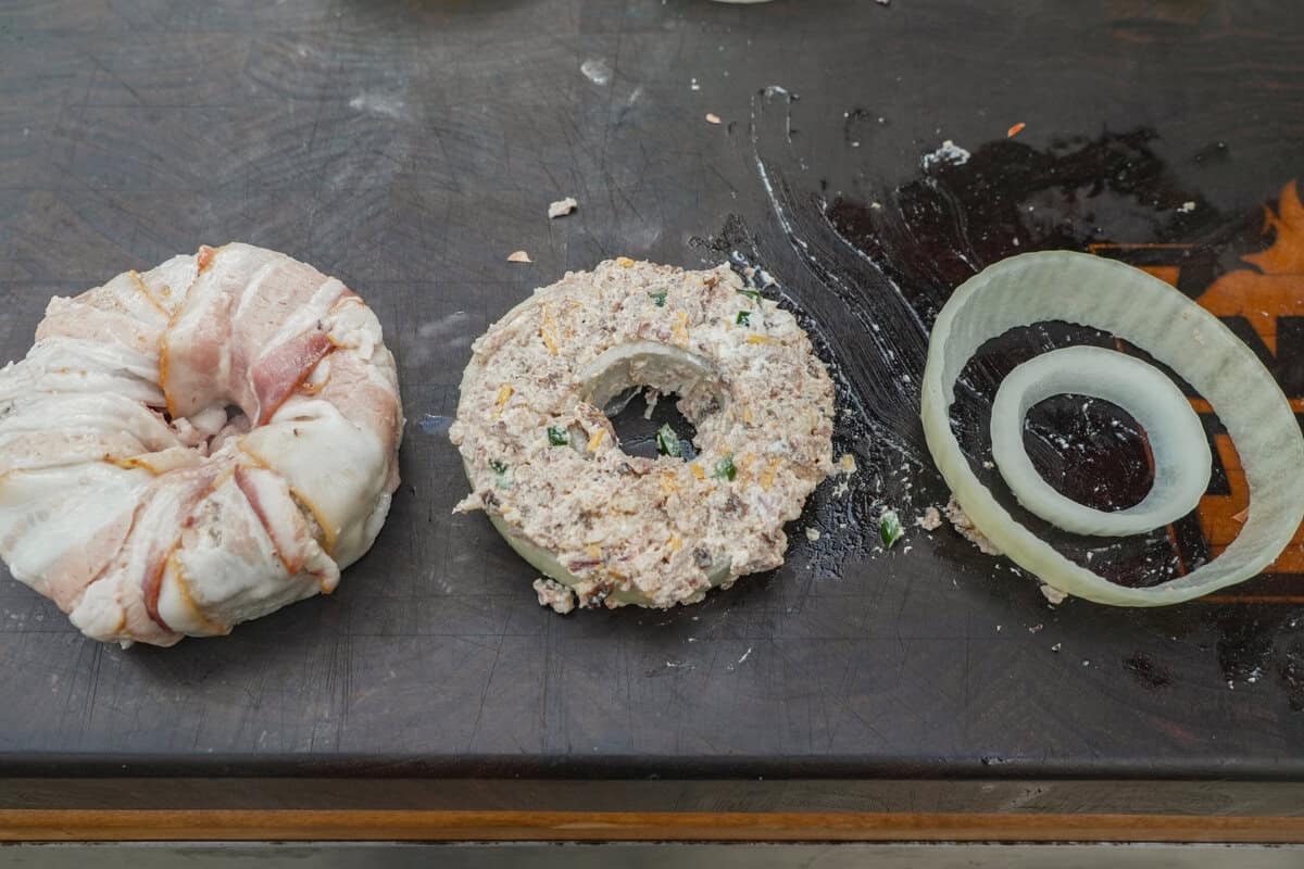A three-step visual of Texas Twinkie stuffed onion ring assembly, with the cut onion rings, then stuffed with filling and then wrapped with bacon