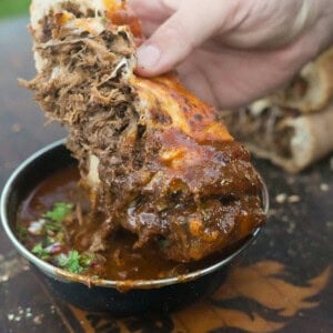 The stuffed bread is dipped into the beef birria sauce for a bite you won't believe.