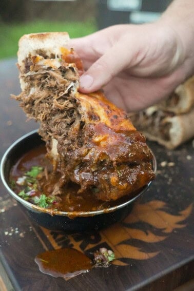 The stuffed bread is dipped into the beef birria sauce for a bite you won't believe.
