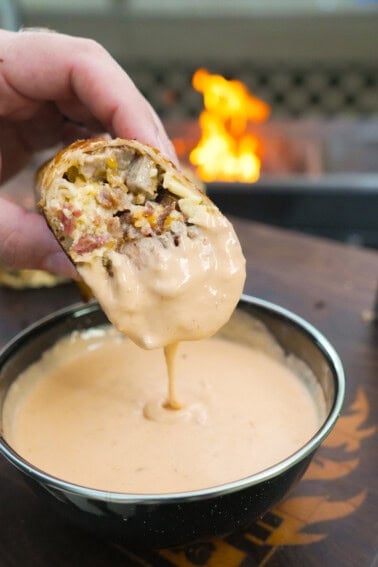 Dipping the steak breakfast burrito in Queso.