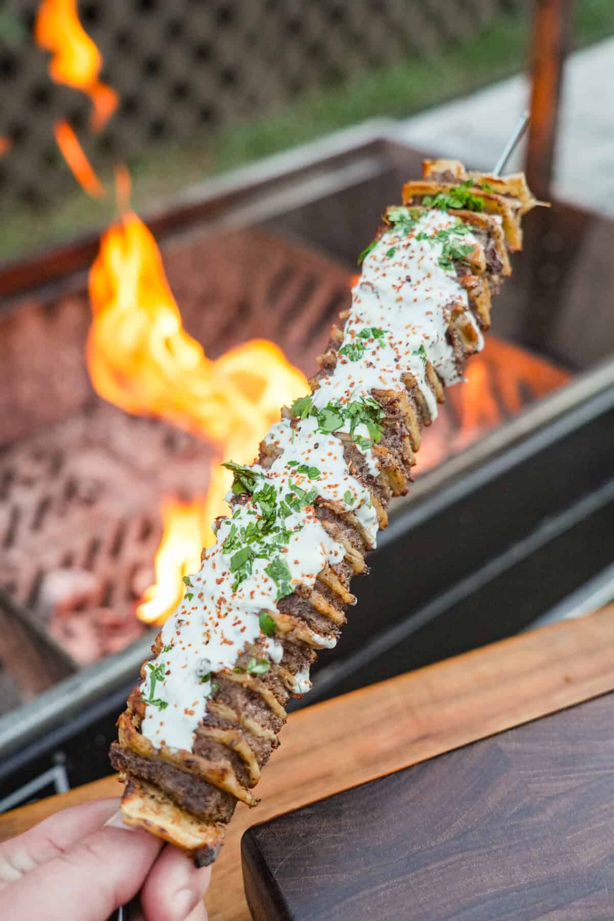 A kebab is cooked and smeared in the creamy jalapeno sauce.