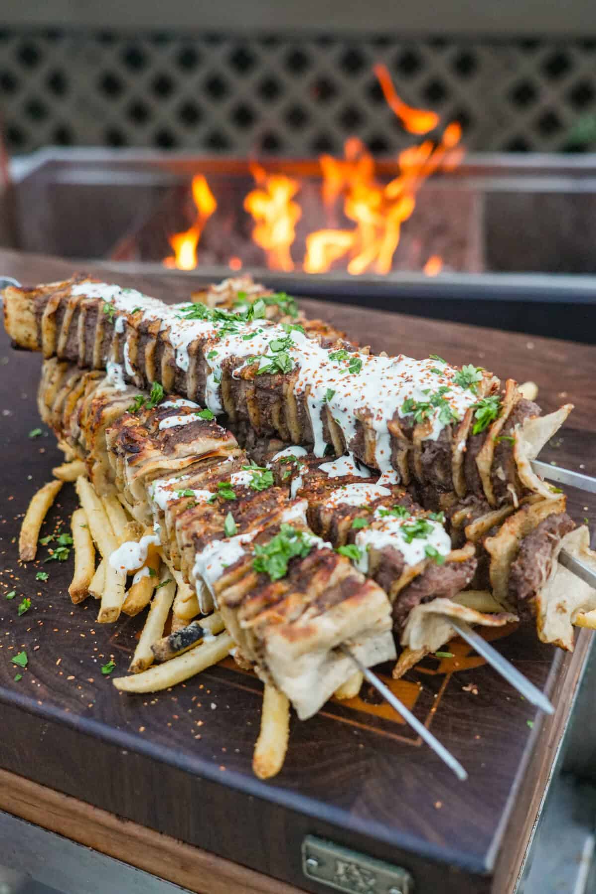 Tortilla Kebabs are done, drizzled with the creamy jalapeno sauce and layered over a bed of crispy French fries.