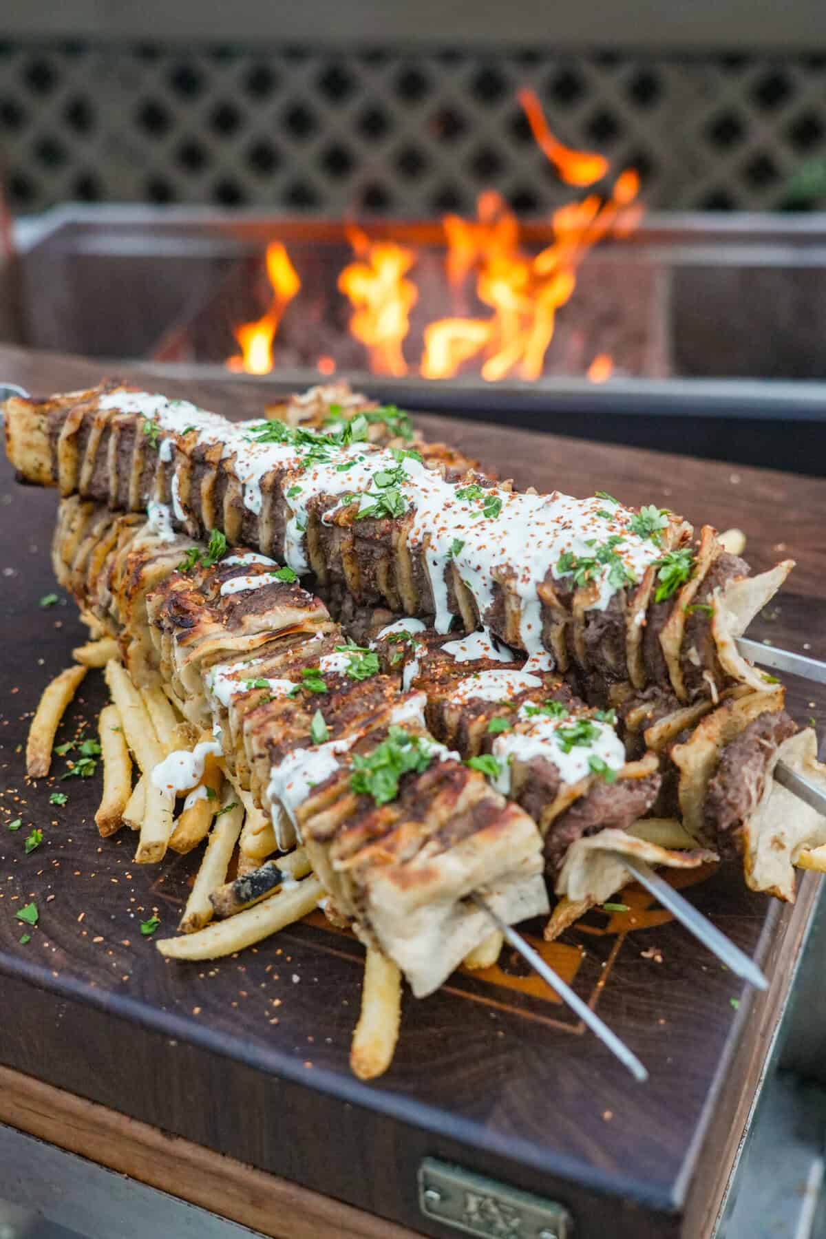 Tortilla Kebabs are done, drizzled with the creamy jalapeno sauce and layered over a bed of crispy French fries. 