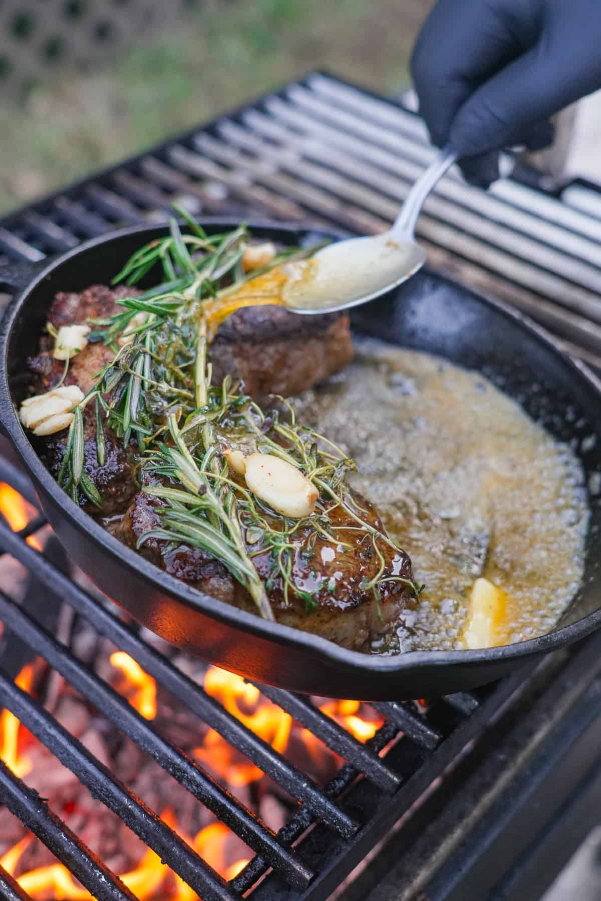 The filet mignon is seared in the cast iron skilled and basted with butter, garlic, and rosemary.