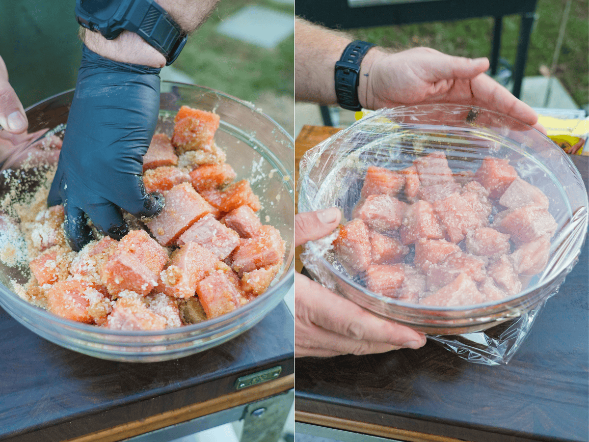 Tossing the salmon cubes with the salt and sugar cure, then placing in a glass bowl and covering with plastic wrap