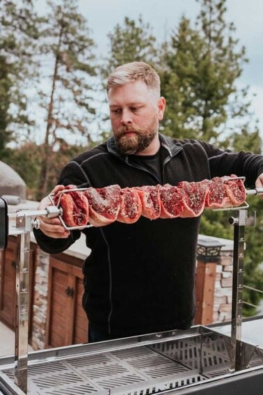 Derek Wolf using the rotisserie attachment on the FYR Grill to cook beef at a high level