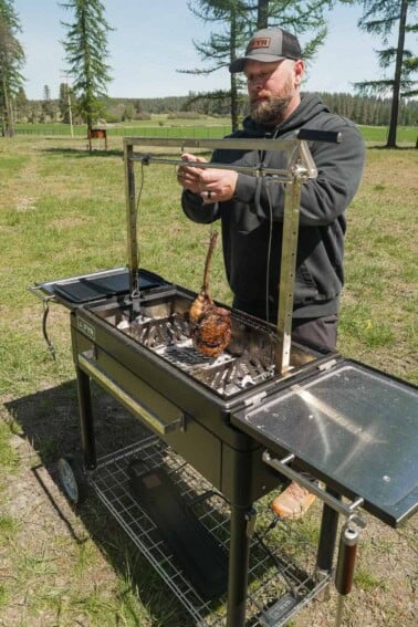 Derek Wolf hanging a tomahawk steak for cooking