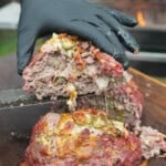 Cutting open a slice of Texas Twinkie meatloaf to show the ingredients — cheese, brisket, bacon bits and jalapeños — stuffed inside
