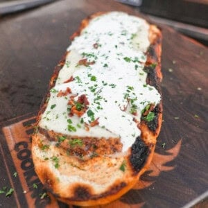 Chicken bacon ranch stuffed bread with mozzarella cheese, bacon bits and chopped chives on top