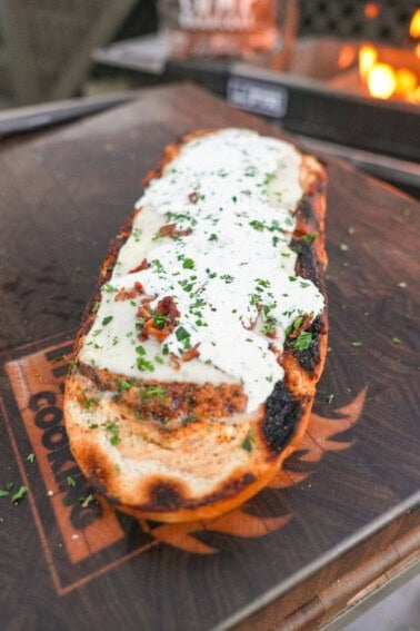 Chicken bacon ranch stuffed bread with mozzarella cheese, bacon bits and chopped chives on top