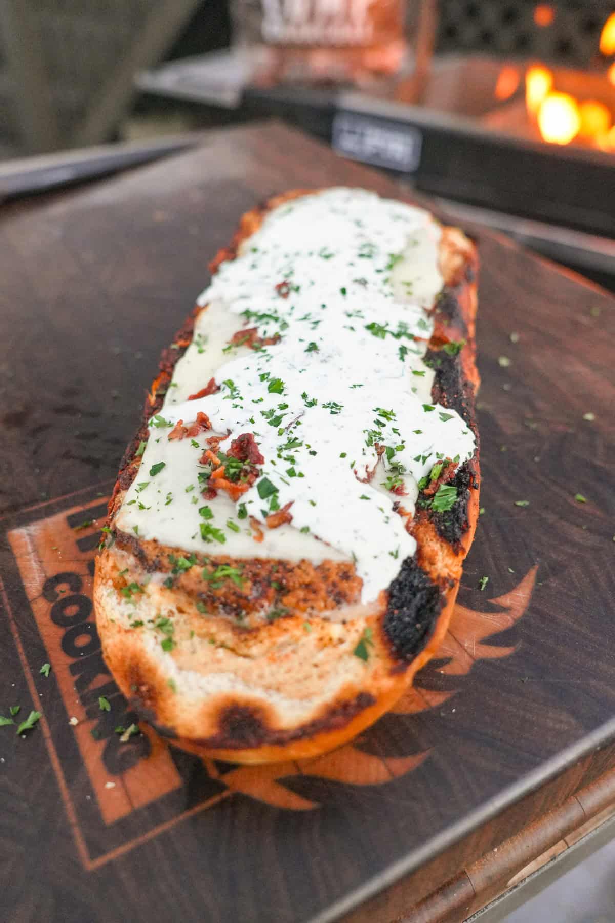 Chicken bacon ranch stuffed bread with mozzarella cheese, bacon bits and chopped chives on top