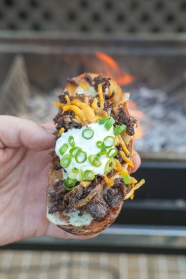 The Steak Fried Potato Skin is held up for a close-up in all its flavorful glory.