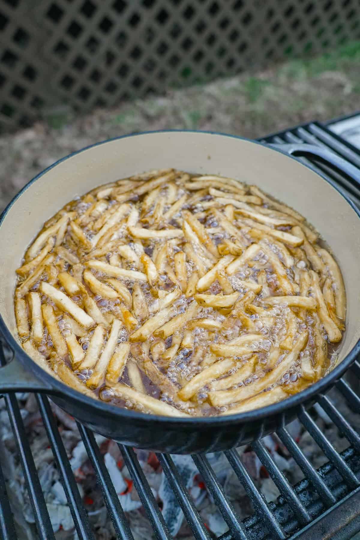 Frying fries in a Dutch oven in beef tallow as a side dish.