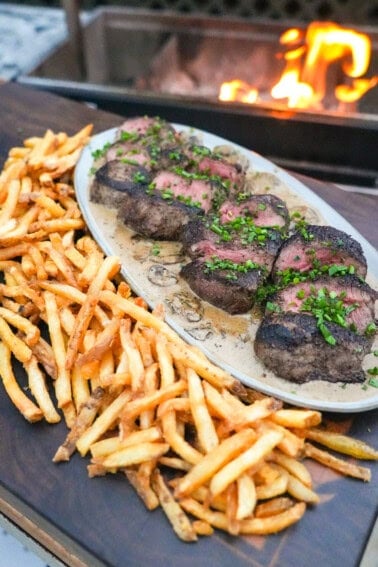 A finished platter of steak Diane with fries on the side