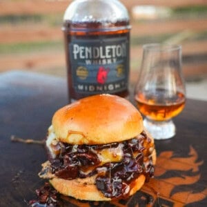 The Whiskey Jam Bacon Burgers recipe cover image features a burger in front of a bottle of whisky.