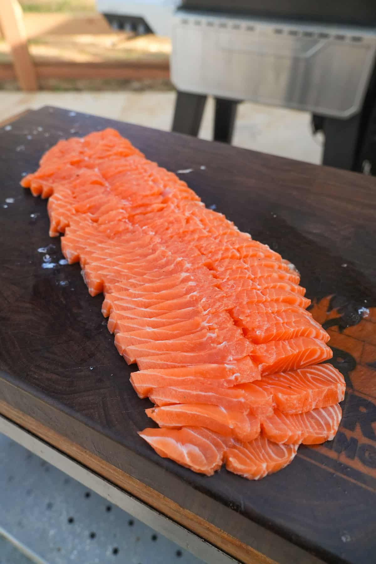 The fresh whole side of salmon is sliced and ready to smoke.