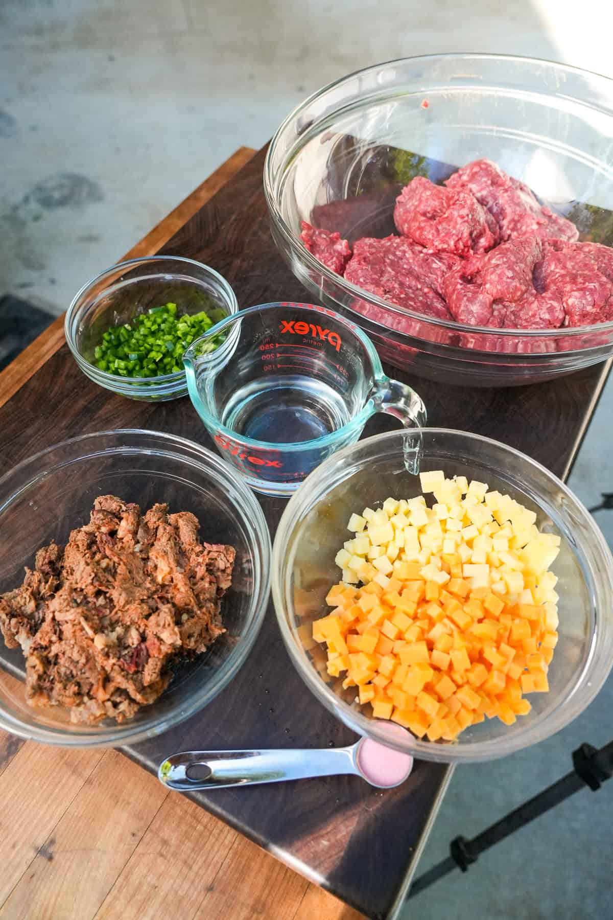 Ingredients for Texas Twinkie beef sticks in bowls: ground beef, diced jalape&ntilde;o peppers, cubed cheese and chopped brisket