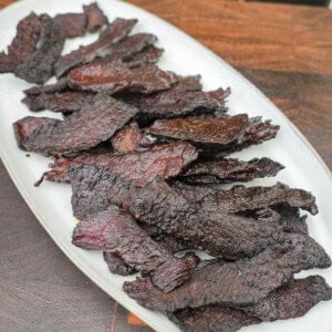 A white platter of finished crispy brisket jerky