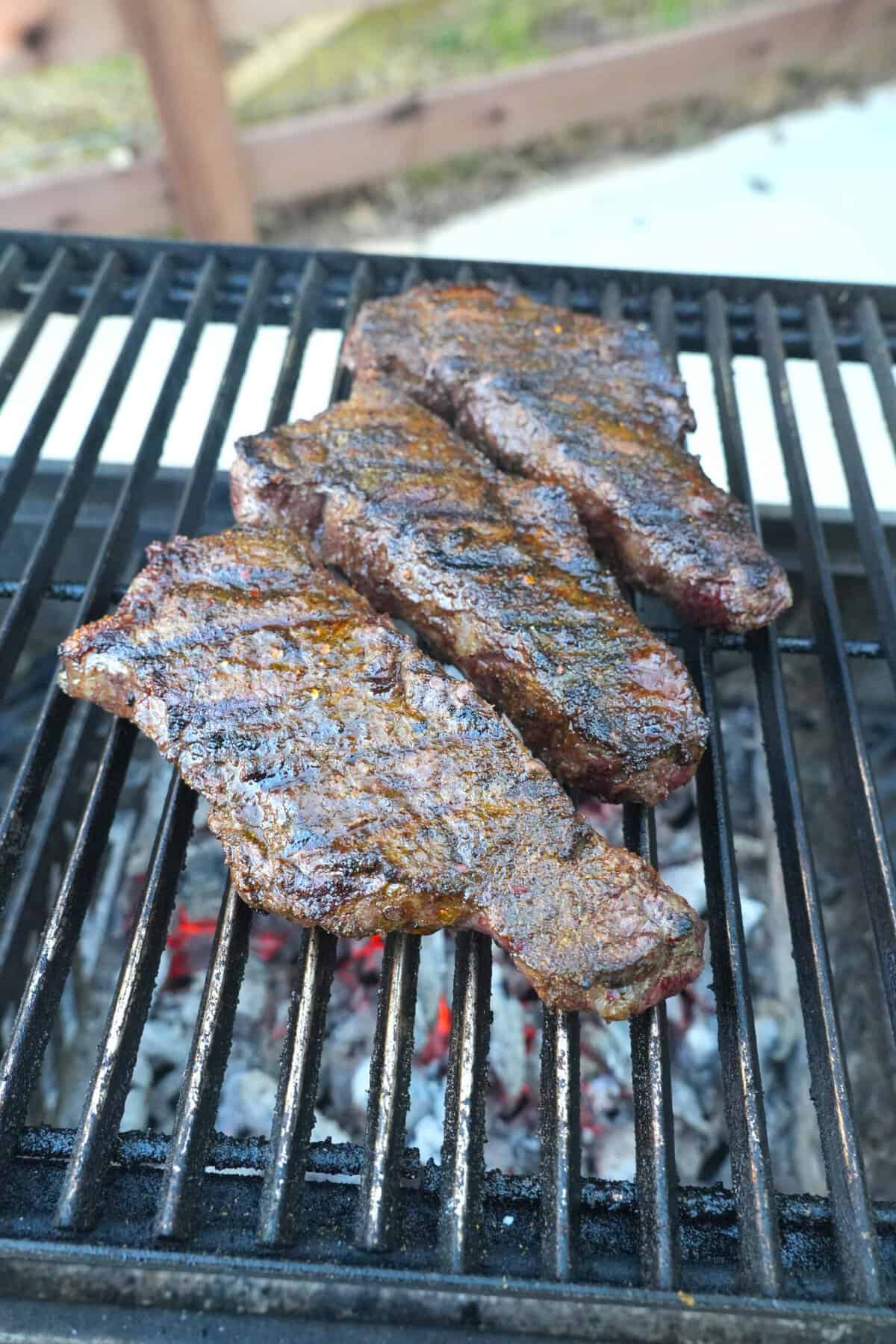 The steaks are seared on the grill, locking in juicy flavor and tenderness.