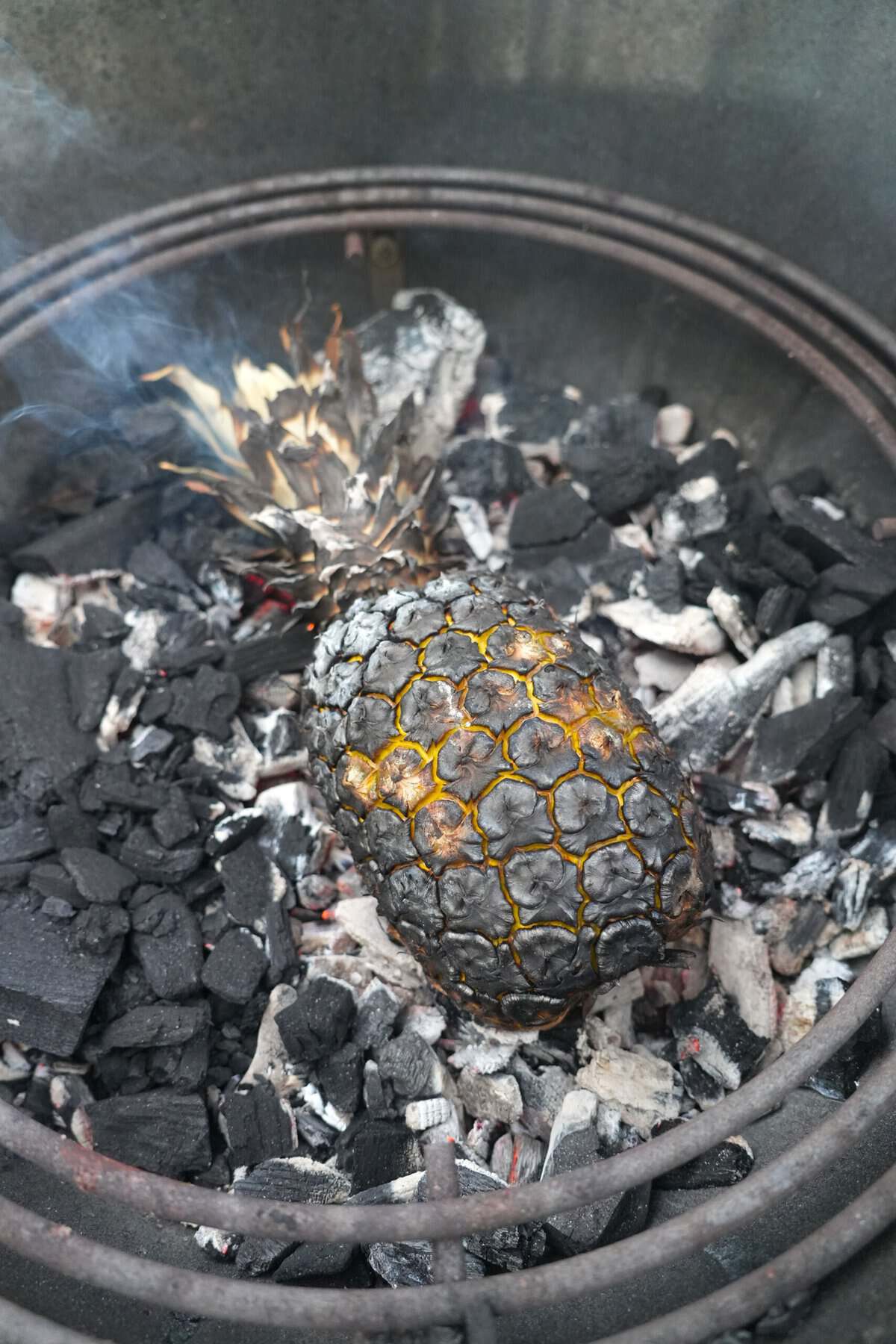 Burnt pineapple on charcoal inside a grill