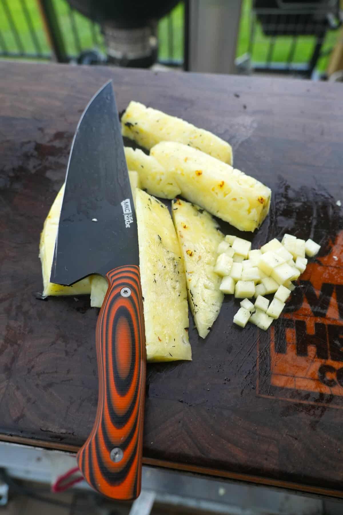 Dicing pineapple on a cutting board with a Montana Knife Company knife