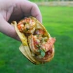 Derek Wolf holding up a finished dirty shrimp taco