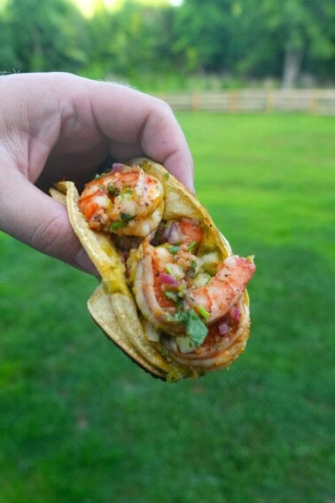 Derek Wolf holding up a finished dirty shrimp taco