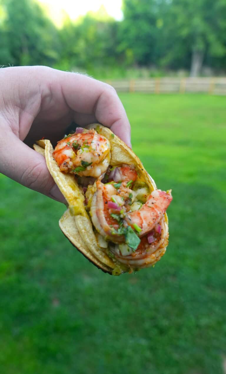 Derek Wolf holding up a finished dirty shrimp taco