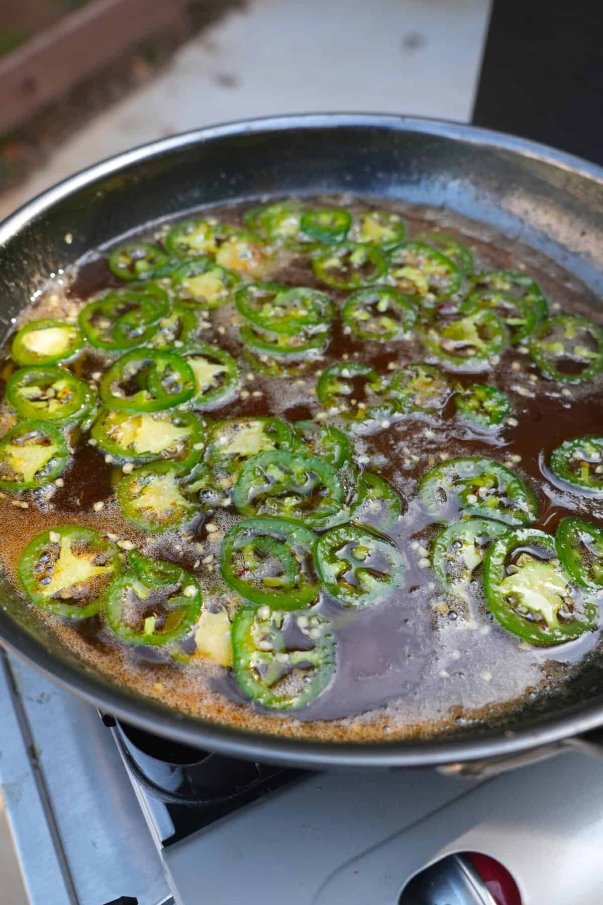 The jalapeno glaze is simmered in a skillet until thick and sticky.