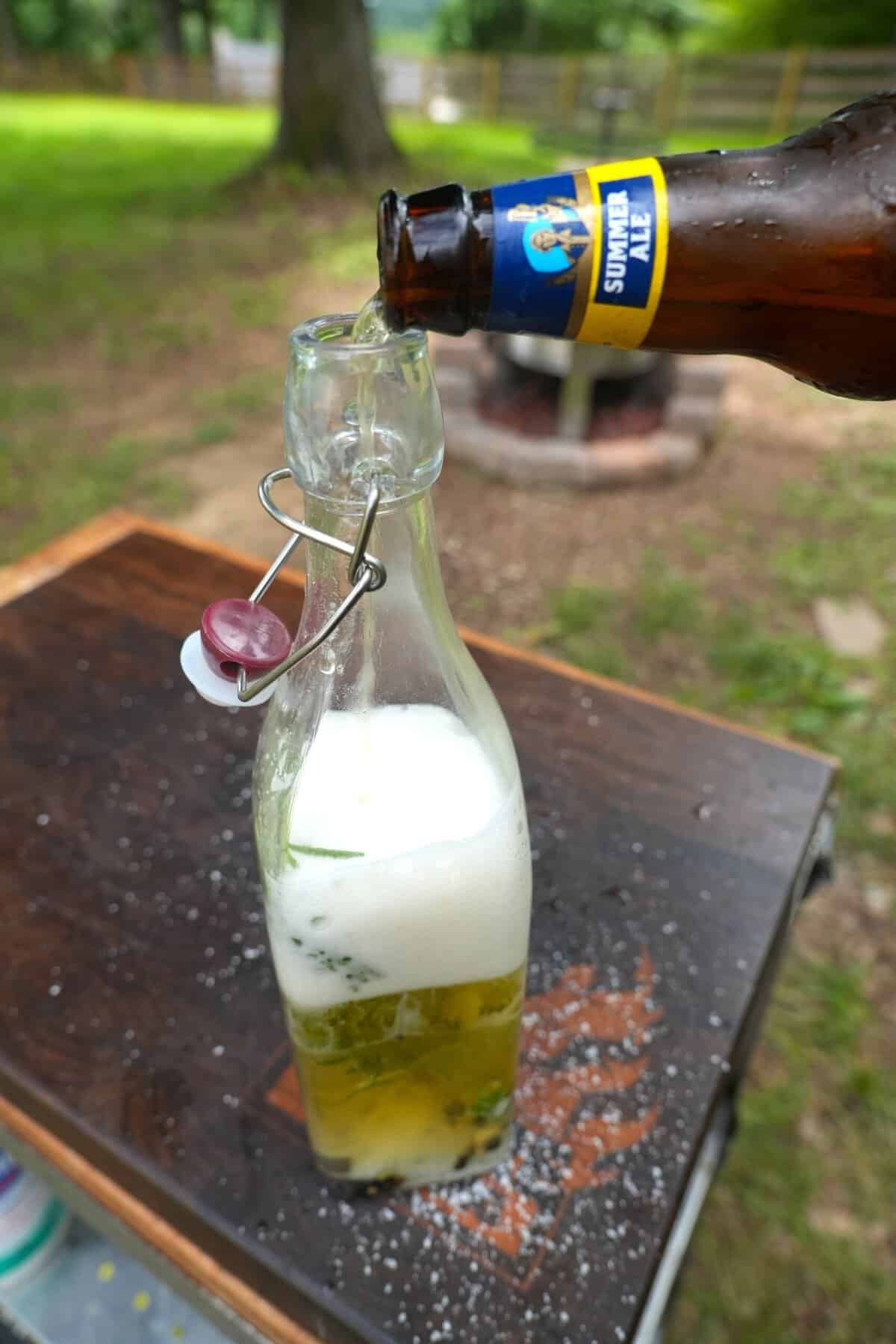 Pouring Sam Summer into a glass bottle of brine ingredients to make beer salmuera