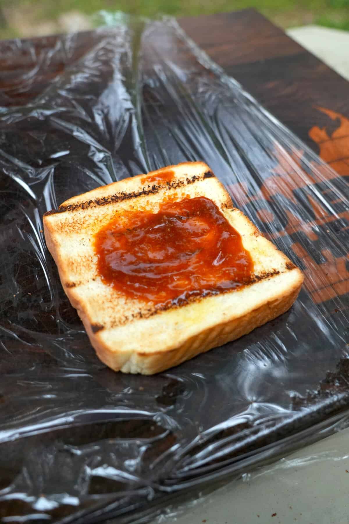 The sauces are smeared on the soft bread before the steak is layered over the top.