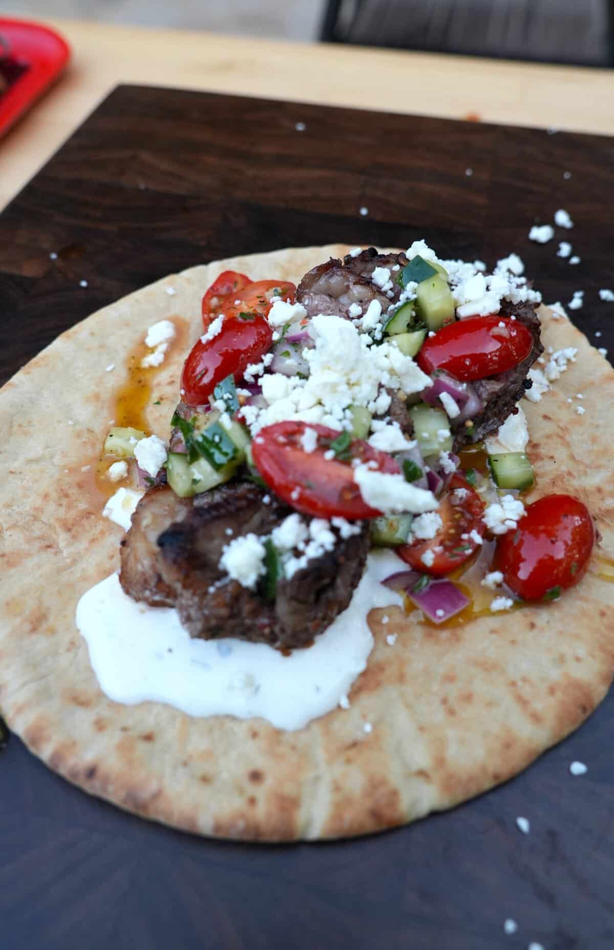 Delicious picanha steak skewers with vegetables on flatbread for grilling.