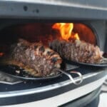 Grilling picanha flake steak skewers over an open flame.