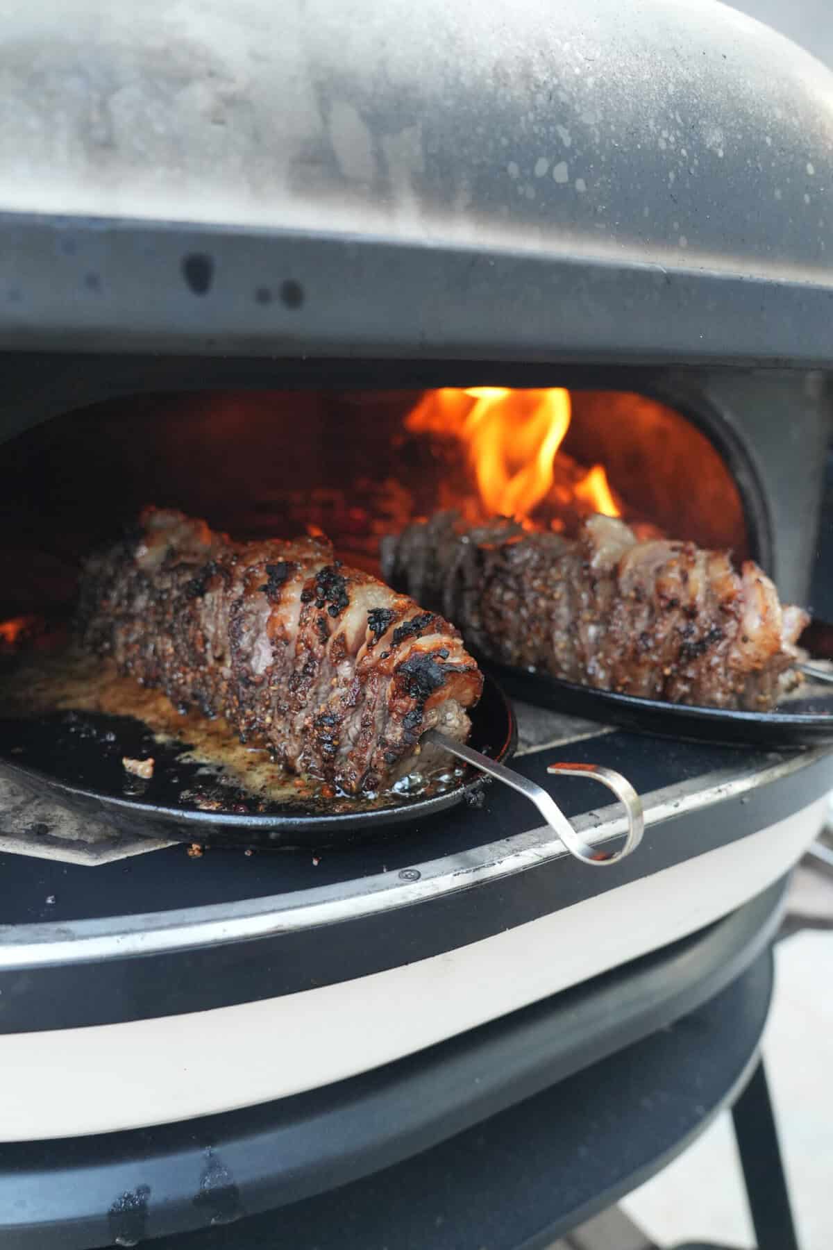 Grilling picanha flake steak skewers over an open flame.