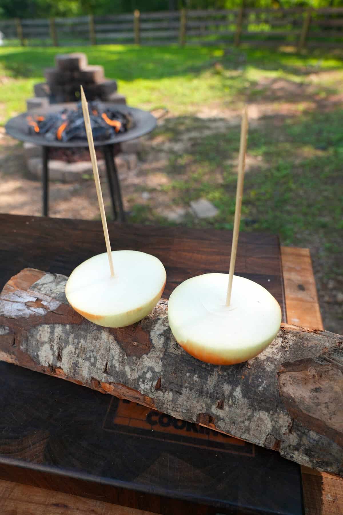 Setting up onion halves with wooden skewers stuck into them for vertical roasting