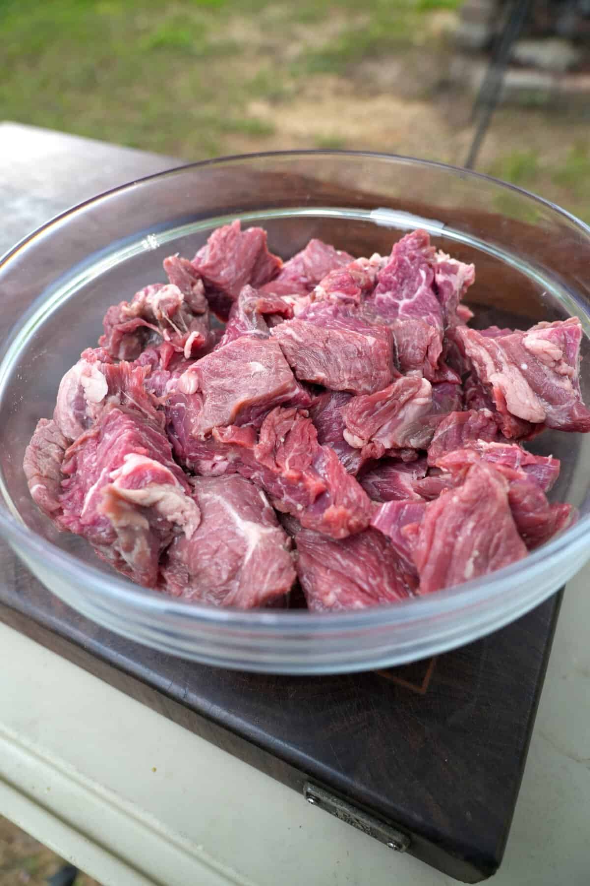 The flap steak is cubed and placed in a bowl before grilling.