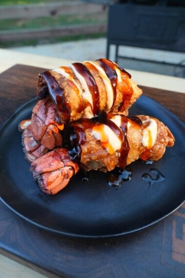 A stack of finished lobster stuffed egg rolls on a plate