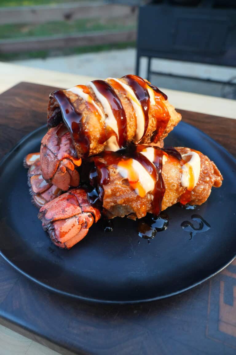 A stack of finished lobster stuffed egg rolls on a plate