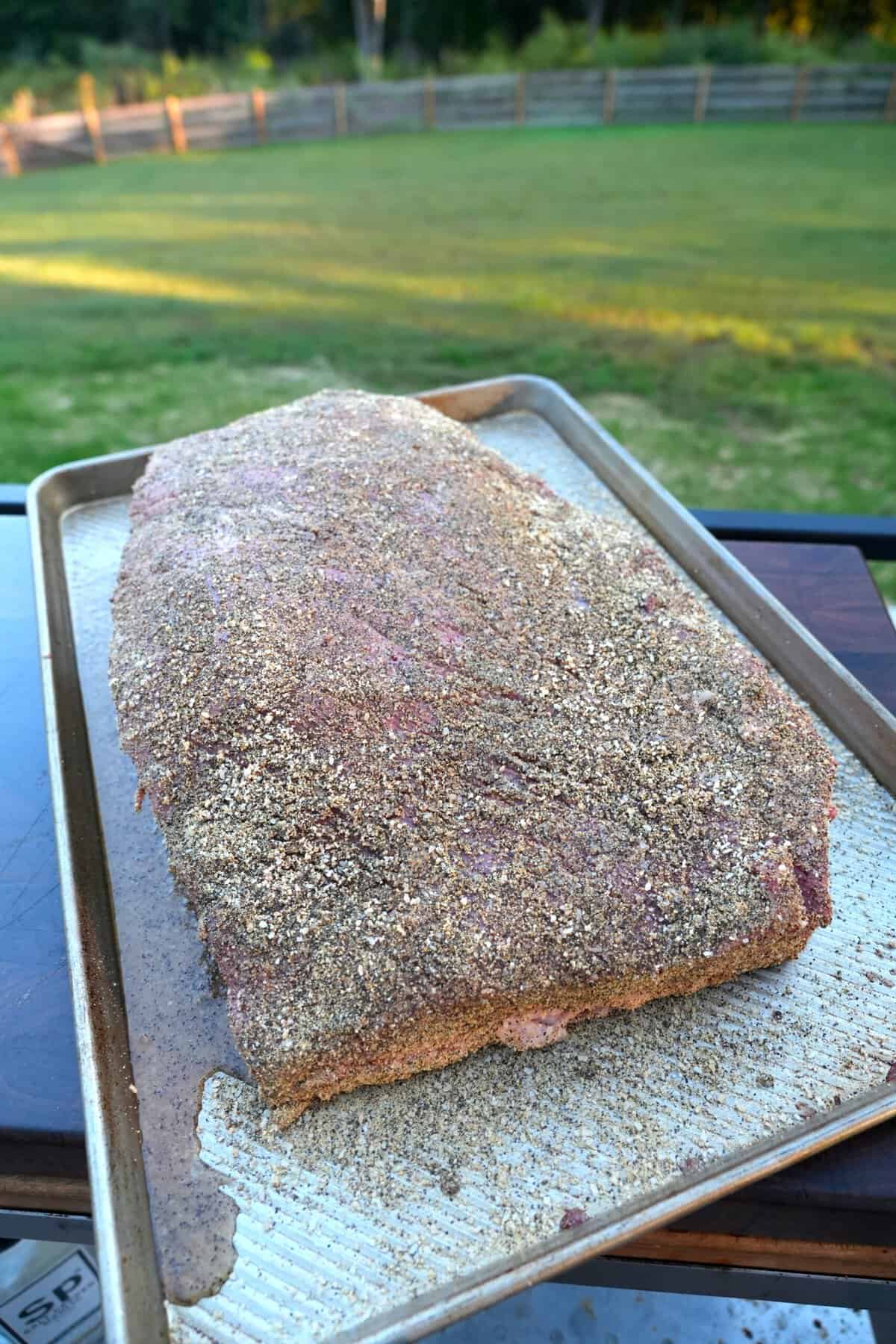 The Whisky Injected Brisket is sitting pretty on a sheet pan, fully seasoned and ready to smoke